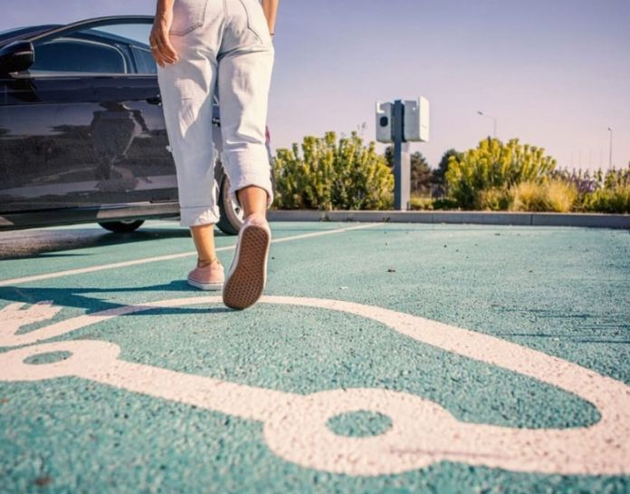 femme marche sur place parking recharge electrique