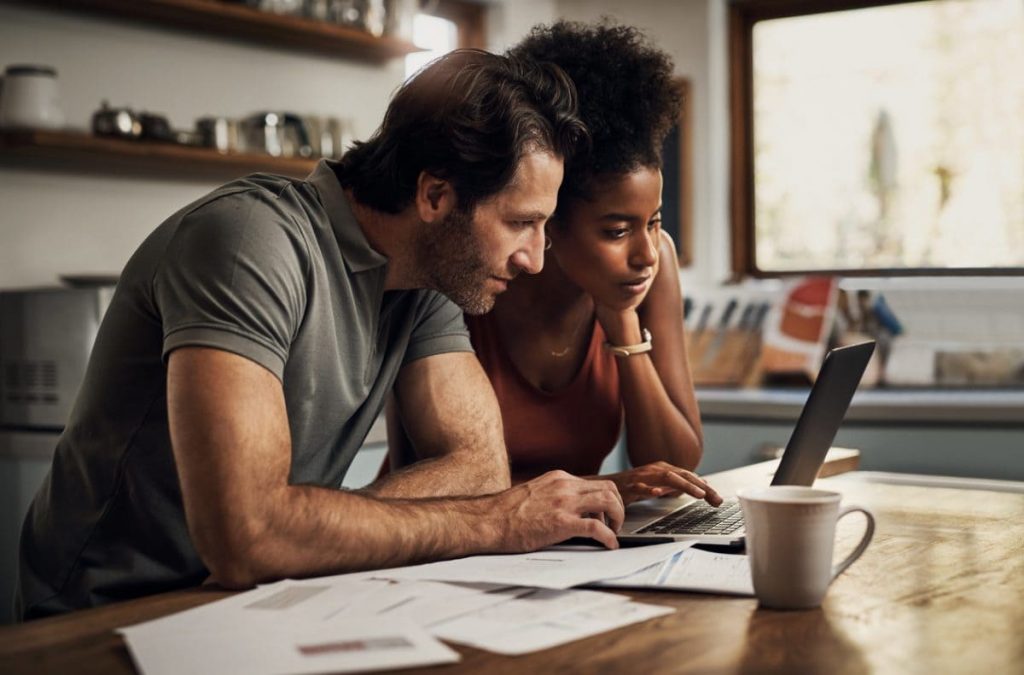 couple jeune consulte facture papier et ordinateur