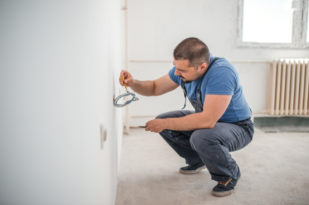 electricien sort fils electriques du mur