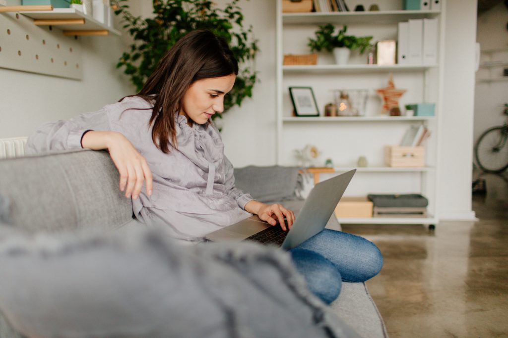 Jeune femme utilise ordinateur maison