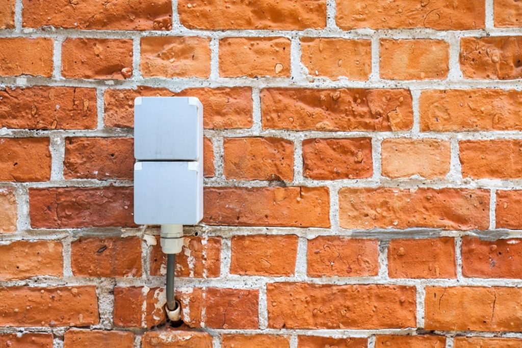 prise exterieure etanche sur mur brique