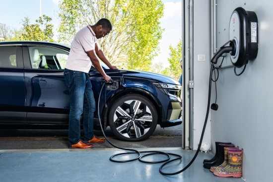 homme branche borne de recharge garage