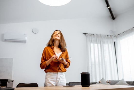 jeune femme leve la tete vers lumiere au plafond
