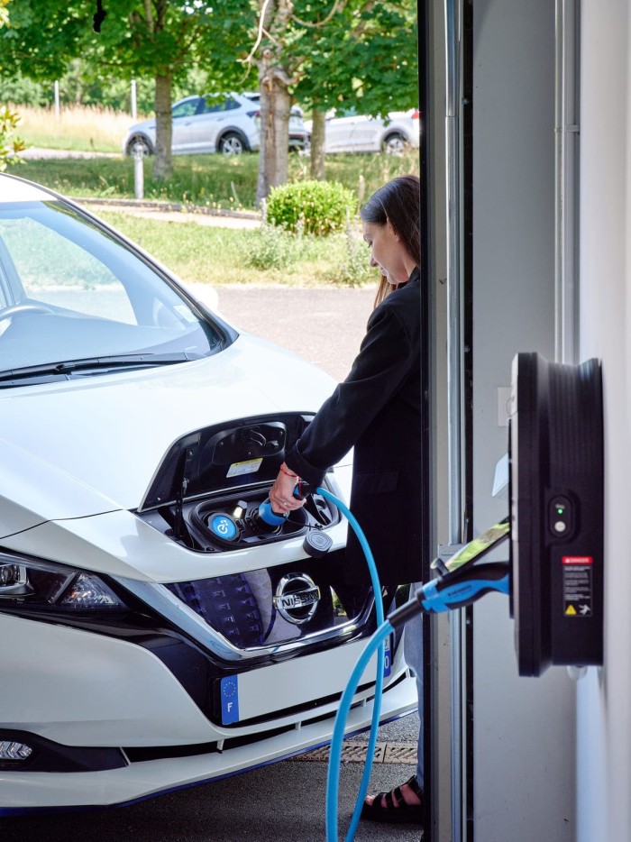 femme recharge son vehicule electrique de fonction